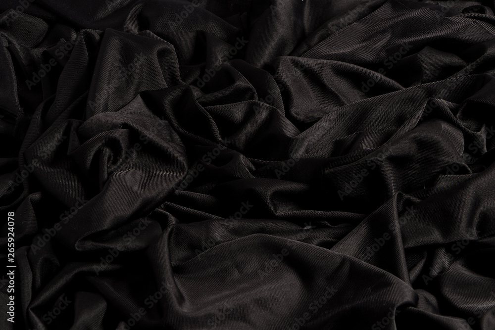 Tela negra brillante con ondulaciones y textura con luz dura y claro oscuro  Stock Photo