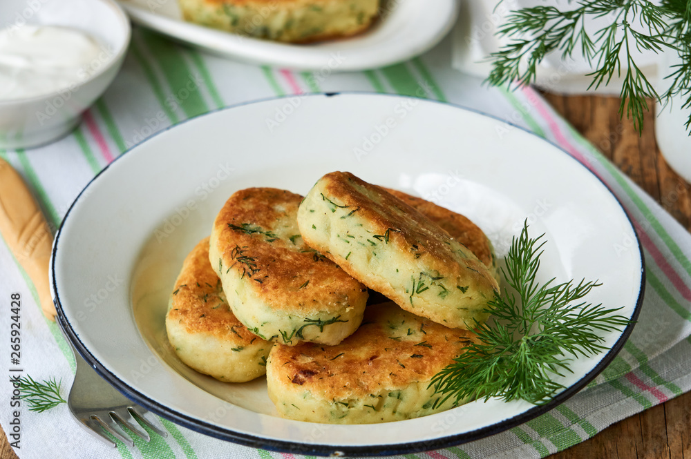 Fried potato cutlets with dill in a white bowl