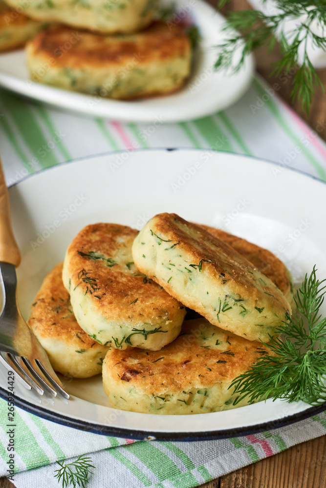 Fried potato cutlets with dill in a white bowl Fried potato cutlets with dill in a white bowl
