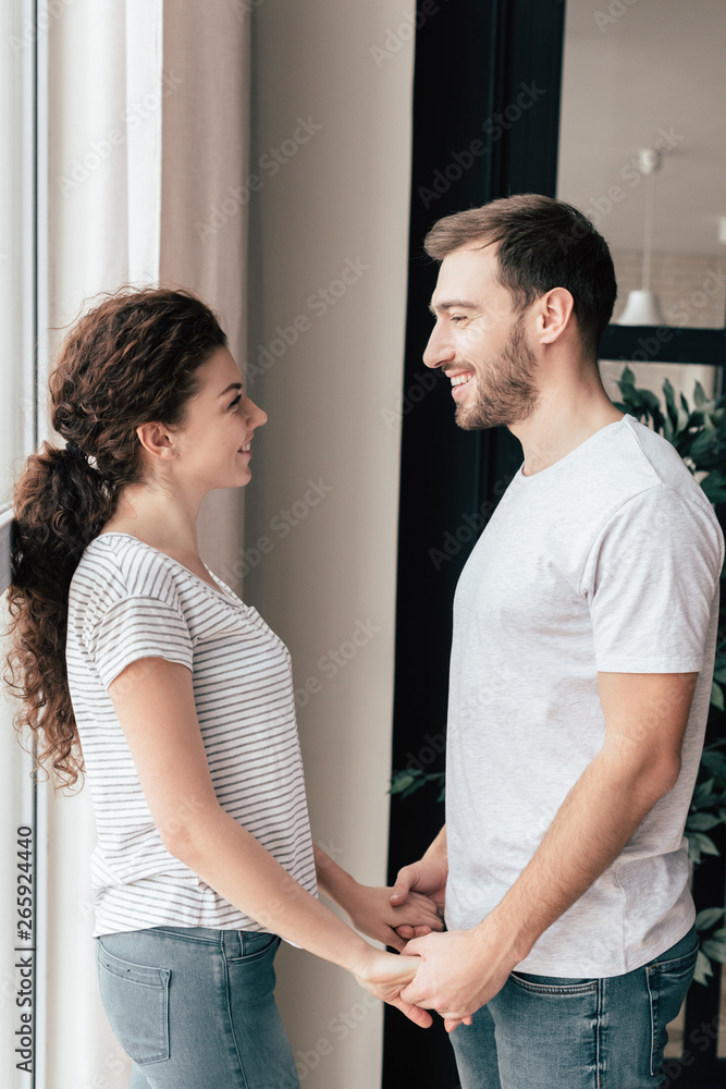 smiling couple holding hands and looking at each other smiling couple holding hands and looking at each other