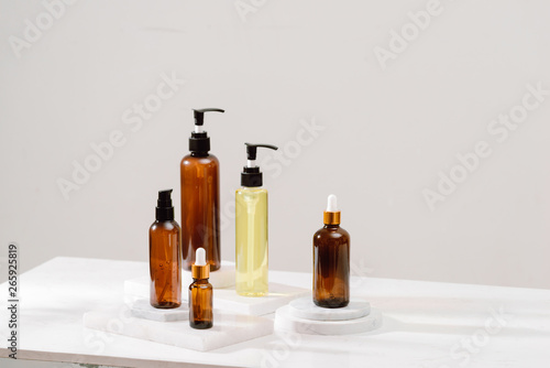 Spa cosmetics in brown glass bottles on gray concrete table. Copy space for text. Beauty blogger, salon therapy, branding mockup, minimalism concept