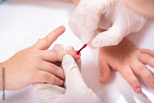Beautician Applying Nail Polish To Girl s Nails