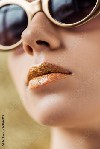 young beautiful woman in sunglasses with shiny golden lips