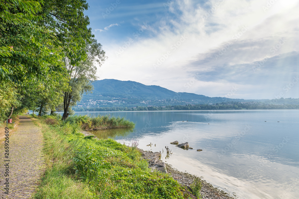 Lake Varese, summer landscape, Italy. Cycle - pedestrian track that runs along all the lake near Biandronno village. In the background the mountain called Campo dei Fiori is visible