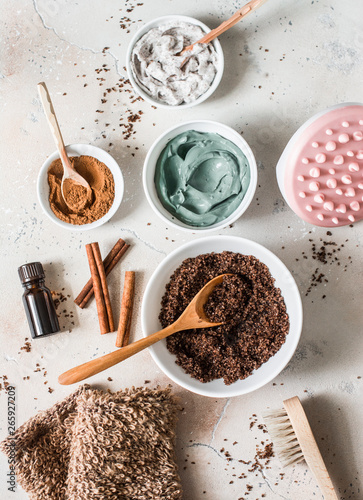 Fotografía Home anti-cellulite products - coffee scrub, cosmetic clay, essential orange oil, hand anti-cellulite massager, nut scrub, cinnamon, natural loofah on a light background, top
