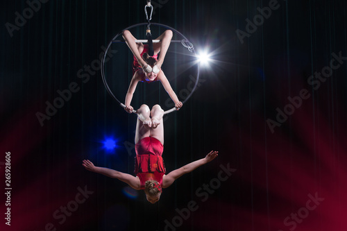 Circus actress acrobat performance. Two girls perform acrobatic elements in the air ring.
