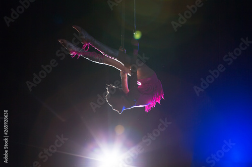 Circus artist acrobat performance. The girl performs acrobatic elements in the air. Circus gymnast on the stage