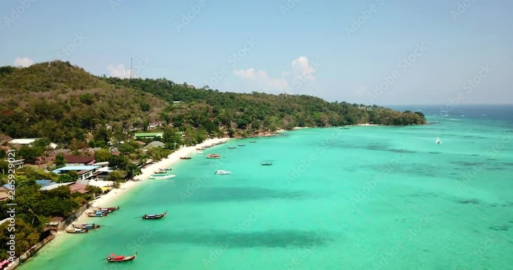 Turquoise clear water. Yachts, boats floating. Water Gradient from light to dark blue. Phi Phi don island, shooting from a drone from the air. White sand, green trees, palm trees and large hills. Turquoise clear water. Yachts, boats floating. Water Gradient from light to dark blue. Phi Phi don island, shooting from a drone from the air. White sand, green trees, palm trees and large hills.