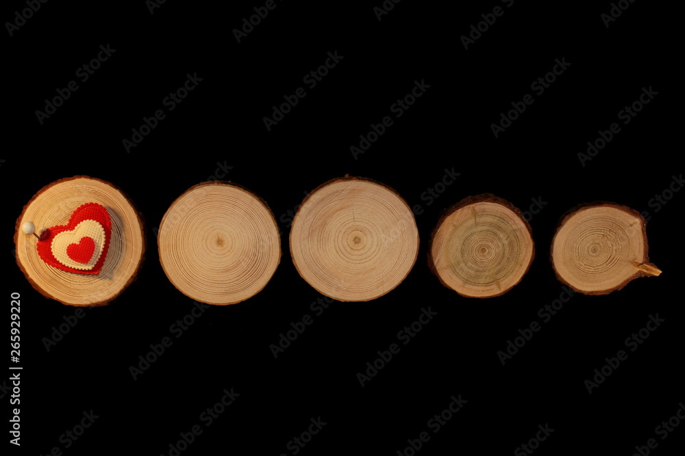 beautiful red heart is nailed to a wooden saw cut on a black background beautiful red heart is nailed to a wooden saw cut on a black background