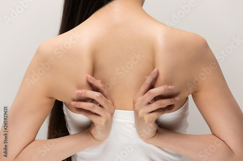 肩甲骨を触る女性