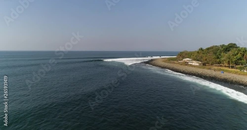 Surfing destination in Central America: Aerial video of Punta Roca, La Libertad, El Salvador. Tropical beach with palm trees behind long waves. Young surfers riding waves in Airflow Creations travel