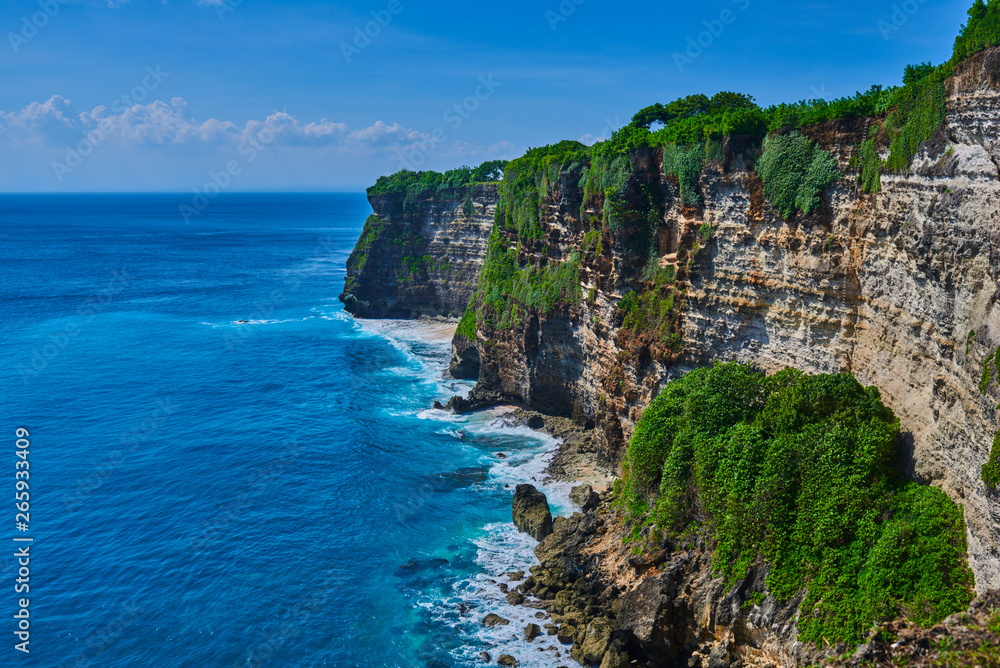 Bali seascape with huge waves and beautiful rocks. Sea beach nature, outdoor Indonesia. Island landscape. Summer holidays at ocean beach. Travel vacation in Indonesia beach. Ecological tourism.