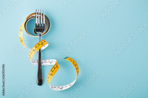 Fotografija Fork with measuring tape around, diet background