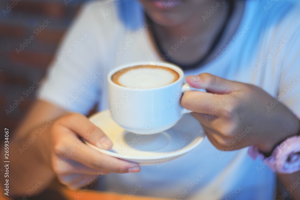 woman holding cup of coffee in front of her woman holding cup of coffee in front of her
