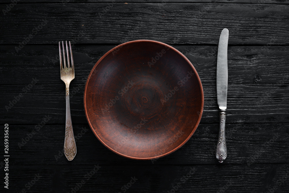 Clay dishes. A plate on a black background. Top view. Free copy space. Clay dishes. A plate on a black background. Top view. Free copy space.