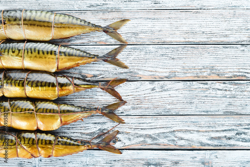 Fototapeta Naklejka Na Ścianę i Meble -  Smoked fish Mackerel. On a white wooden background. Top view.