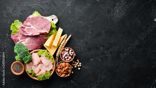 Assortment of healthy protein source and body building foods. Meat, chicken fillet, broccoli, beans, cheese, eggs, wheat. On a stone background.