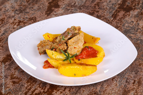 Baked pork meat with potao and tomato photo