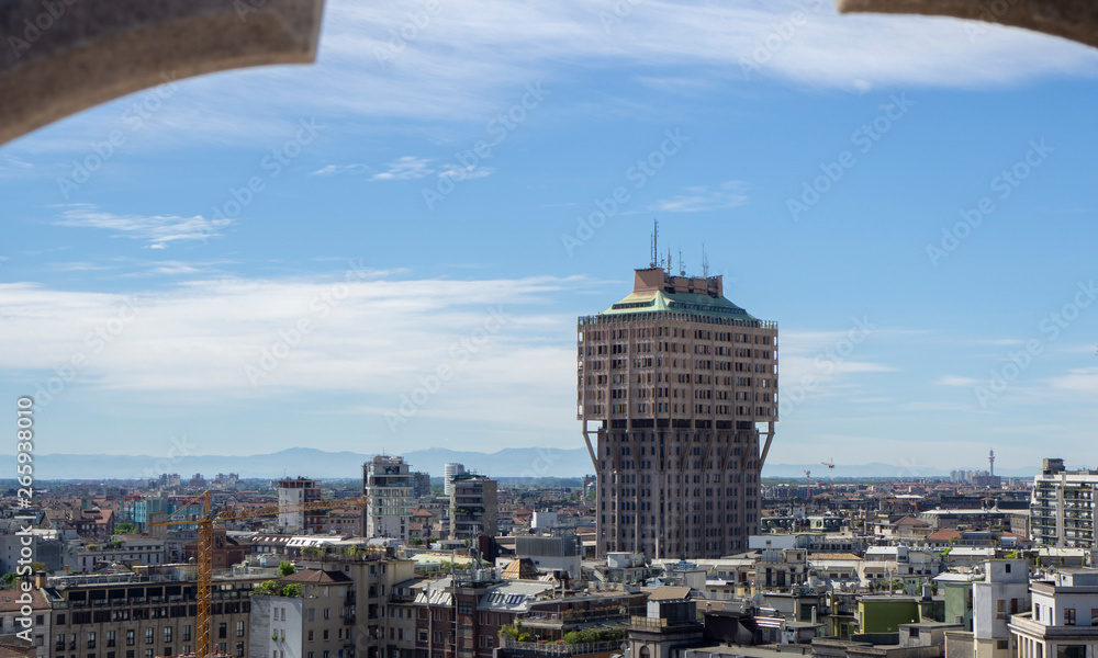 Milano, Italy. Panorama of the city and the Velasca skyscraper from the roof terrace of the cathedral. The white marble spires of the Duomo