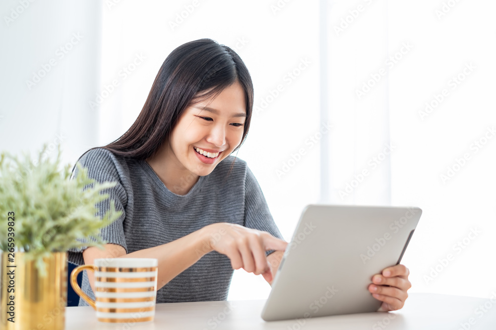 Young Asian woman using internet tablet for online shopping, lifestyle concept Young Asian woman using internet tablet for online shopping, lifestyle concept