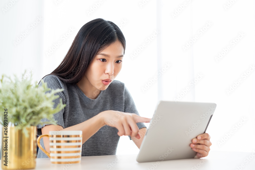 Young Asian woman using internet tablet for online shopping, lifestyle concept Young Asian woman using internet tablet for online shopping, lifestyle concept