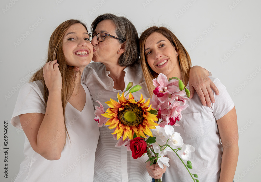 mother and two twin sisters enjoy in very funny attitude with a big sunflower in their hands mother and two twin sisters enjoy in very funny attitude with a big sunflower in their hands