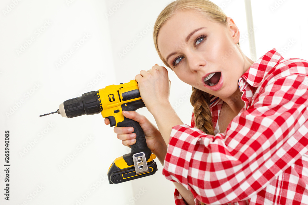 Woman having troubles using drill Woman having troubles using drill