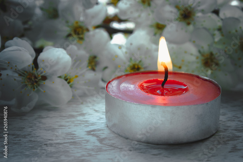 Red candle with white cherry branches.