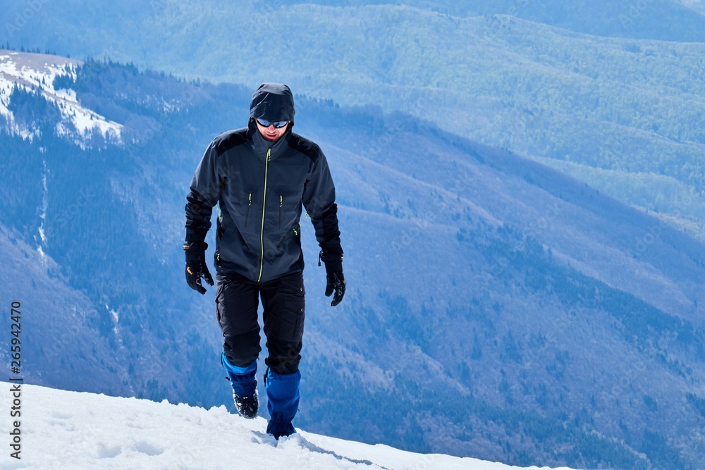 tourist mountaineer climbs over the snowy mountains to the summit