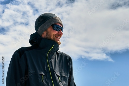 happy tourist in the glasses, against the blue sky © Mykhailo
