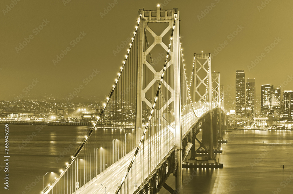 Fototapeta premium View of Bay Bridge across San Francisco Bay with lots of cars passing through in San Francisco at night.
