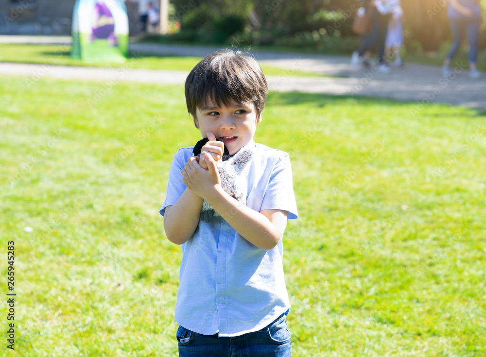 High key light Portrait cute kid boy with smiling face holding toy standing in the park with bright light in summer, Playful child playing outdoors in spring or summer, Positive children concept High key light Portrait cute kid boy with smiling face holding toy standing in the park with bright light in summer, Playful child playing outdoors in spring or summer, Positive children concept