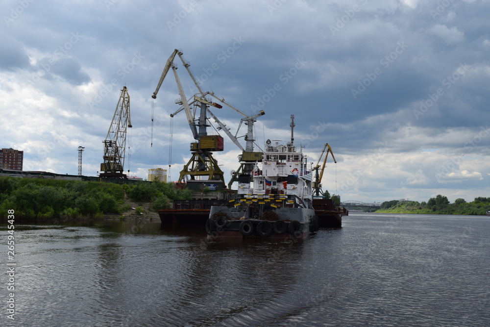 Unloading the ship in the Tyumen river port. Tura River, Tyumen, Russia