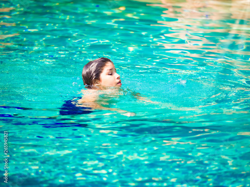 Boy in swimming pool. Cute teenage boy. © catherinelprod