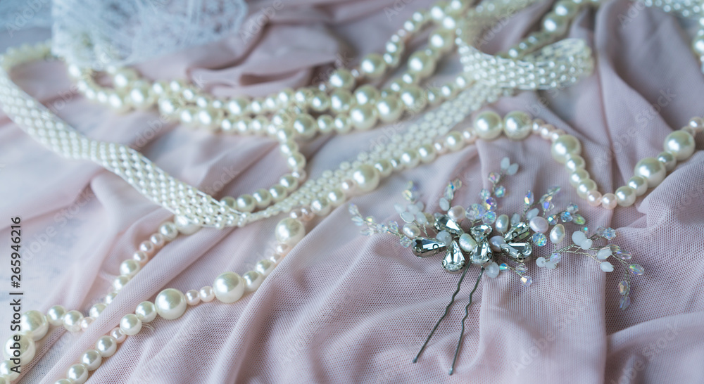 Wedding background with pearls and hair accessories on pink background Wedding background with pearls and hair accessories on pink background
