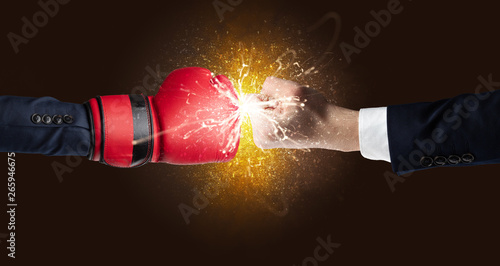 Two hands fighting with orange dust, spark, glow and smoke concept   © ra2 studio