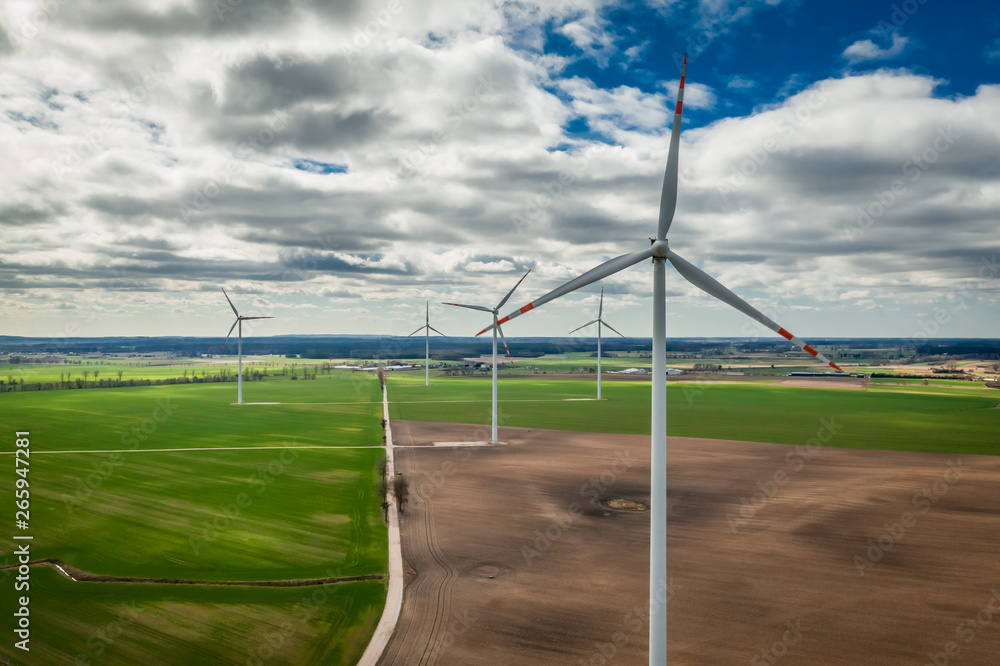 White wind turbines in a brown field, aerial view White wind turbines in a brown field, aerial view