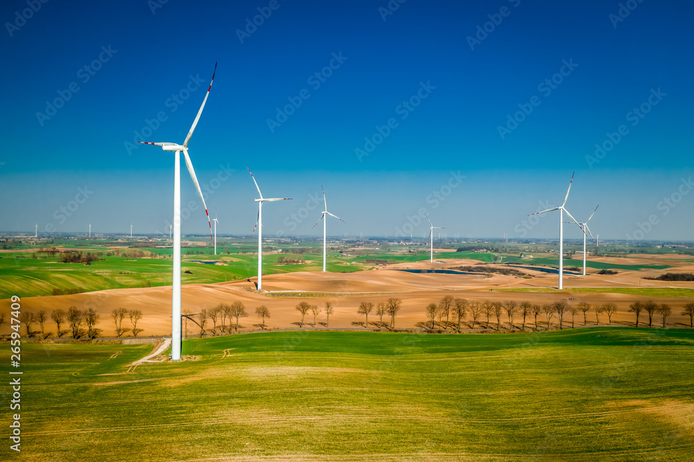 Flying above big wind turbines in a field Flying above big wind turbines in a field