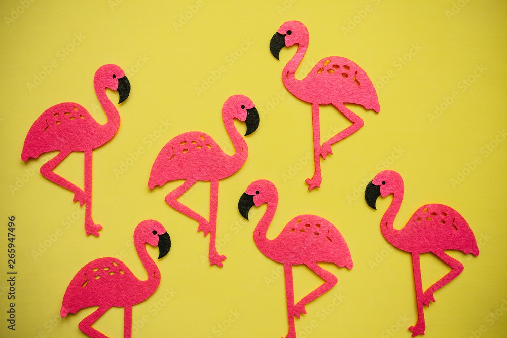 Many felt pink flamingos on a yellow background. Summer design. Many felt pink flamingos on a yellow background. Summer design.
