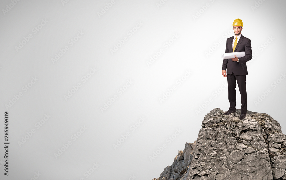 Young business person on the top of the rock with copy space
Young business person on the top of the rock with copy space