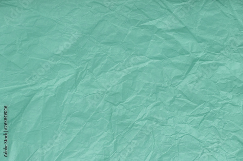 Texture of crumpled turquoise, wrapping paper, closeup. Green old background