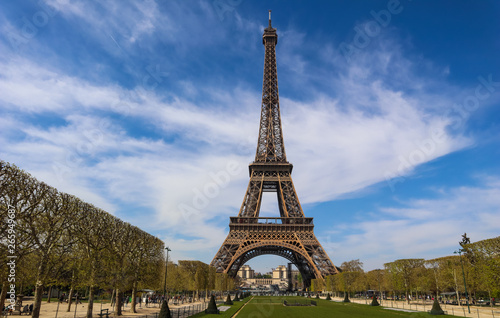Eiffel Tower in Paris France against blue sky with clouds. View from a tourist bus. April 2019