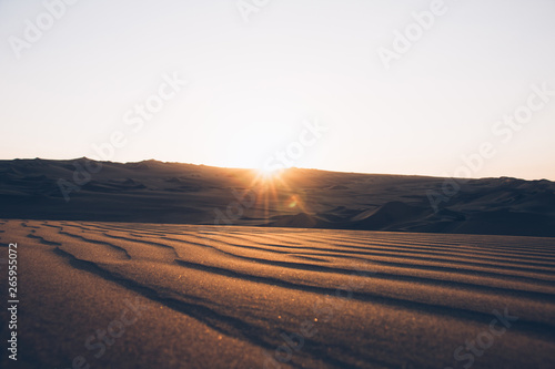 Beautiful sand dunes ripples in the desert, warm dry sand at sunset. Nature landscape. Huacachina desert, Ica Region, Peru. Toned image.