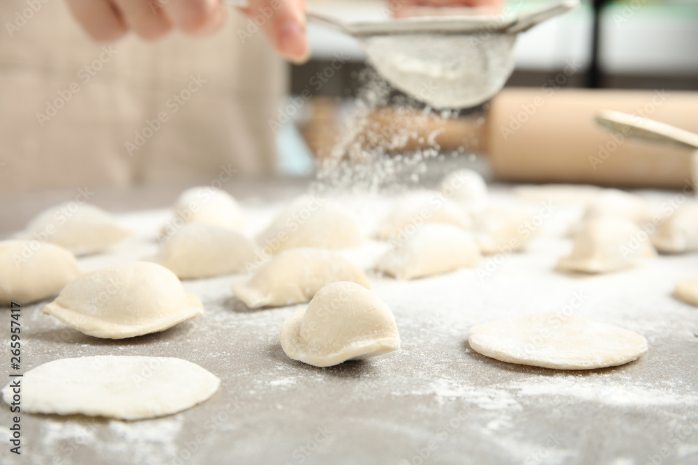 Woman cooking delicious dumplings at table, closeup Woman cooking delicious dumplings at table, closeup