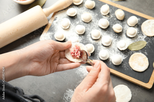 Woman cooking delicious dumplings over table, above view