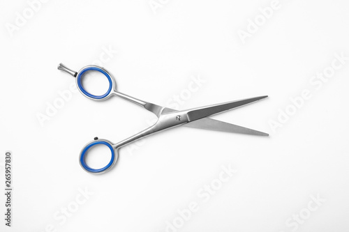 New scissors on white background, top view. Professional hairdresser tool