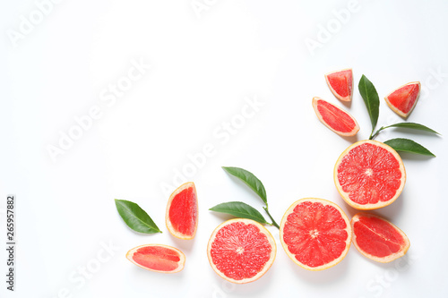 Frame made of grapefruits and leaves on white background, top view with space for text. Citrus fruits