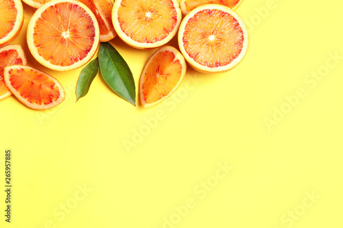 Fresh bloody oranges on color background, flat lay with space for text. Citrus fruits