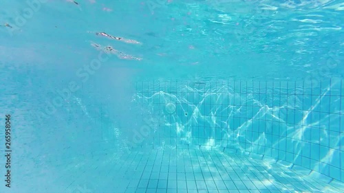 Someone diving into swimming pool at the background of waves texture on the pool bottom