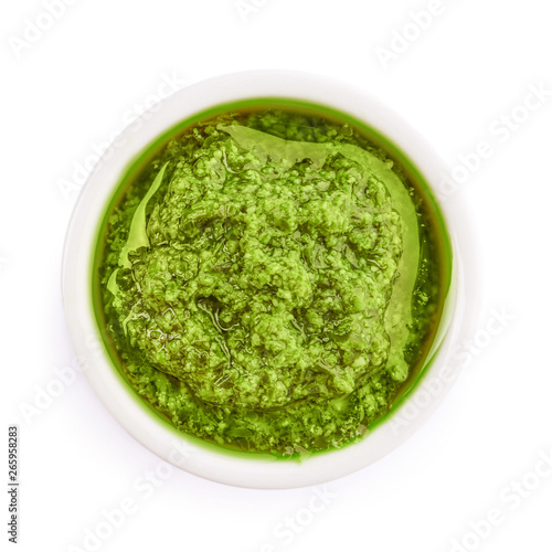 Fotografiet Bowl of tasty pesto sauce isolated on white, top view